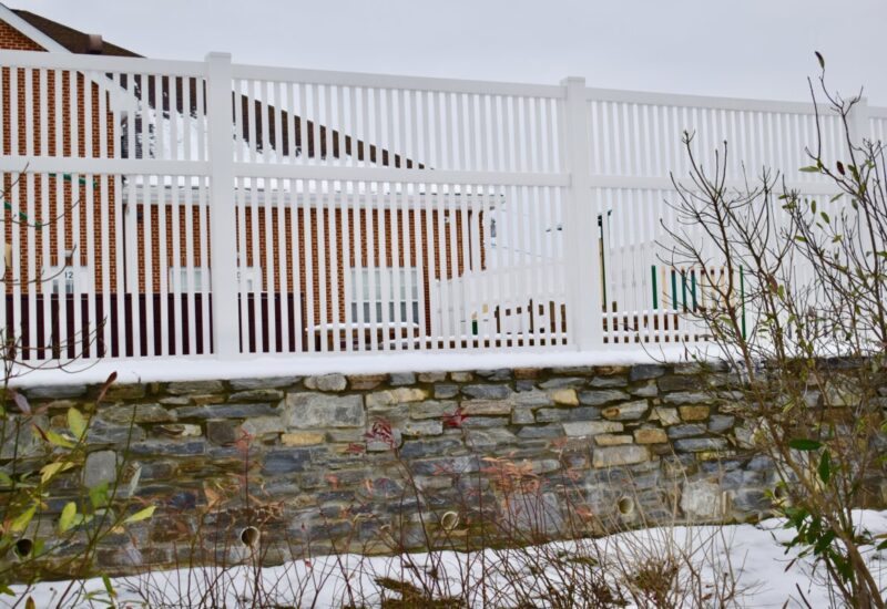 Greenbrier White 6' High Greenbrier with Mid-Rail mounted onto stone wall